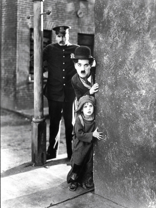 Charlie Chaplin och en pojke tittar fram bakom ett hörn.
