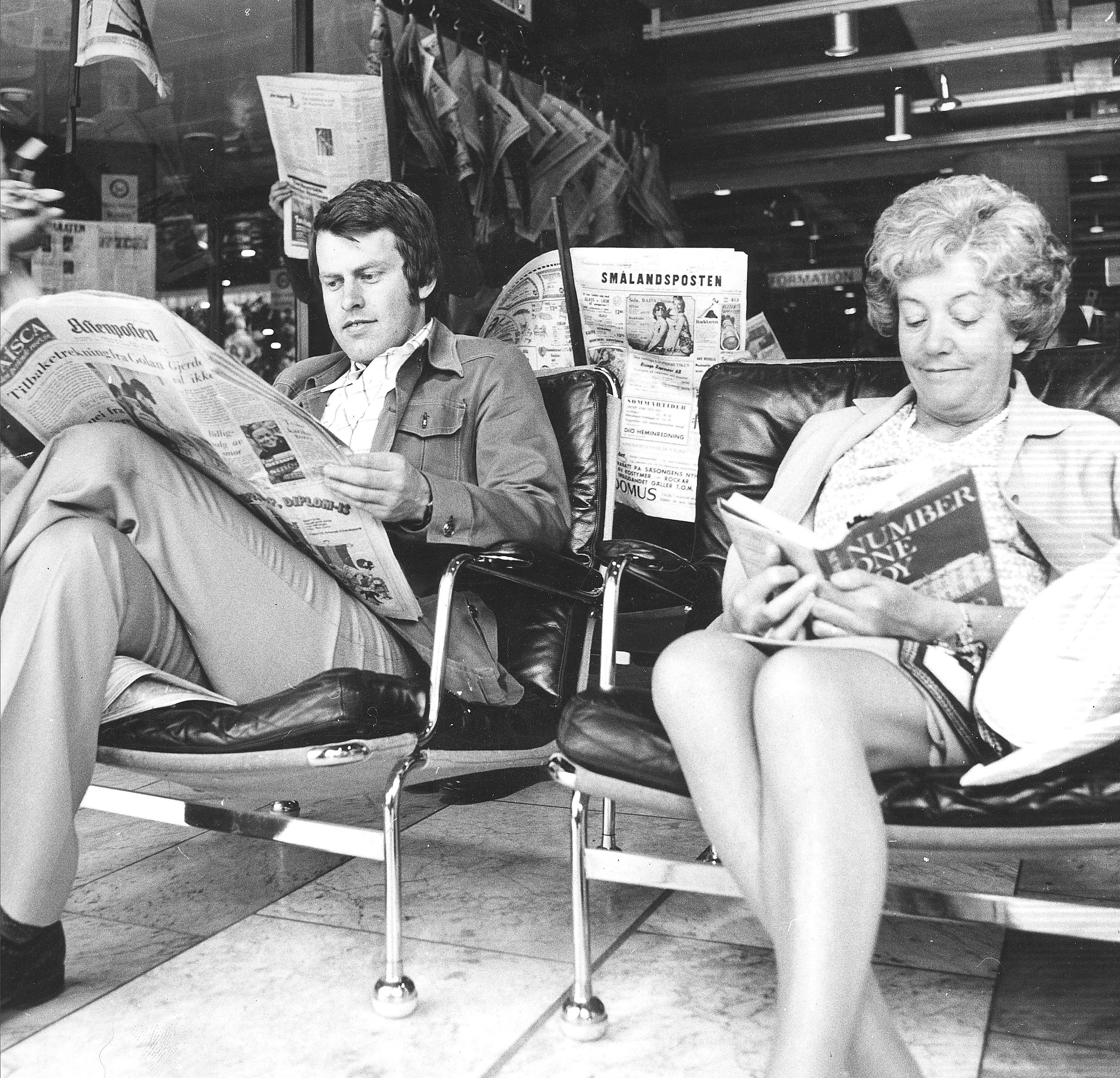 Det är 70-tal, en man och en kvinna sitter i varsin fåtölj i Kulturhuset och läser böcker och tidningar. 